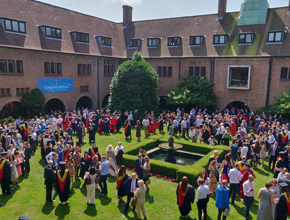 Graduates surround the library quad as they prepare for group photograph